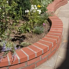 a brick garden bed with flowers growing in it