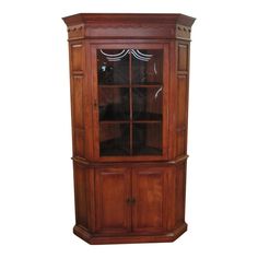 a wooden china cabinet with glass doors on the top and bottom shelves, in front of a white background