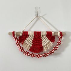 a red and white wall hanging with rope