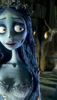 the corpse girl is dressed in blue and has long black hair, with eyes wide open