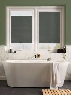 a white bath tub sitting next to two windows