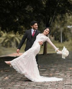 a bride and groom holding each other in their arms on a cobblestone walkway