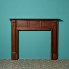 an empty fireplace in a room with a blue wall and carpeted flooring on the ground