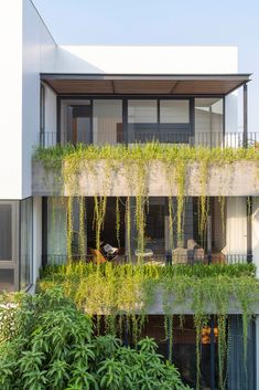 an apartment building with plants growing on the balcony