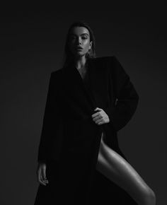 a woman is posing for a black and white photo with her legs spread out in the air