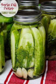 pickles and broccoli are in mason jars on a red and white towel