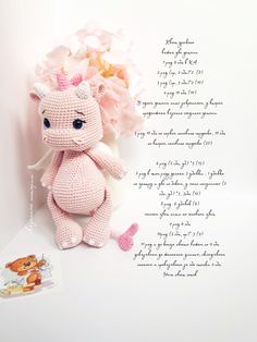 a pink crocheted stuffed animal next to a bouquet of flowers and a poem