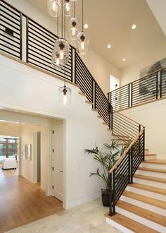 an open floor plan with stairs and chandelier