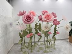 pink and white flowers are arranged in vases on the floor next to each other