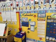 a classroom wall with calendars and books on it