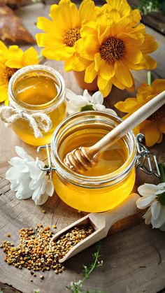 a wooden table topped with honey and flowers