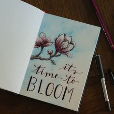 an open book with writing on it next to a pen and ink drawing flowers in the background