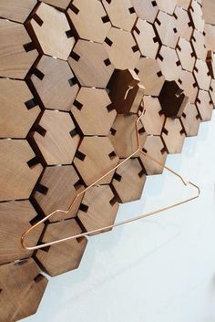 a wall sculpture made out of wood with metal rods attached to the sides and hexagonal shapes on each side