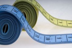 two blue and yellow measuring tape on white surface