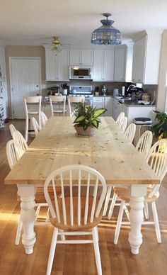 a large wooden table surrounded by white chairs