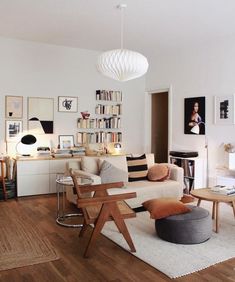 a living room filled with furniture and bookshelves on the wall next to a wooden floor