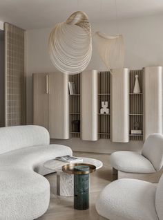 a living room filled with white furniture and wooden shelves