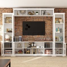 an entertainment center with bookshelves and a television mounted on the brick wall behind it