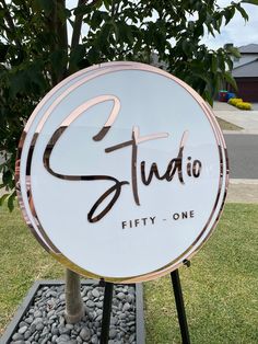 a sign that says studio fifty one in front of some grass and rocks on the ground