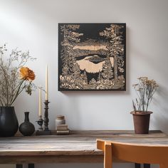 a wooden table topped with vases filled with flowers next to a painting on the wall