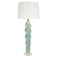 a table lamp with a white shade on it and a gold trim around the base