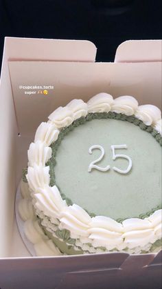 a white cake in a box with the number twenty five on it's side