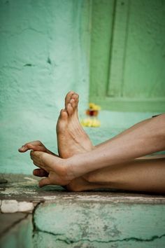 a person sitting on the ground with their legs crossed and one foot in the air