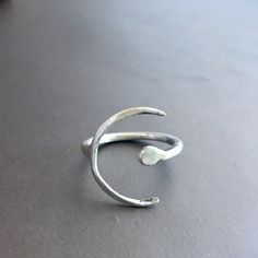 Sterling silver open band crescent ring. Super simple but lovely lunar ring. The ring is somewhat adjustable, but the band is made to stay in place, and not get bent out of shape, so you can only change the size a tiny bit. I love that this ring is both a Crescent moon and a fermata symbol. The fermata is a musical notation which indicates that one should pause or hold....a great reminder to all of us to pause and be present in the moment, to rest and enjoy the music of our life. Minimalist Adjustable Crescent Ring, Minimalist Silver Moon Phase Ring, Minimalist Moon Phase Open Ring Jewelry, Minimalist Silver Moon Midi Rings, Minimalist Silver Moon-shaped Midi Rings, Minimalist Hand Forged Open Midi Rings, Minimalist Silver Midi Rings In Moon Shape, Minimalist Adjustable Moon Phase Rings, Adjustable Minimalist Moon Midi Rings