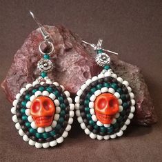 If you love skull jewelry, these beaded earrings are for your! Brown, green and ivory seed beads are stitched around an orange howlite carved skull bead forming a delightful mandala shape reminiscent of the Dia de los Muertos style. Day Of The Dead Beaded Jewelry Gift, White Bohemian Skull Jewelry, Handmade Skull Earrings For Day Of The Dead, Bohemian Handmade Skull Earrings, Mexican Beadwork, Beaded Orange, Mandala Earrings, Carved Skull, Flower Skull