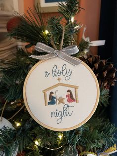 a cross stitch ornament hanging from a christmas tree