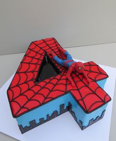 a spiderman themed cake on top of a white table