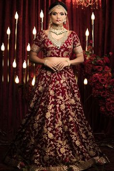 Wedding lehenga choli in maroon royal velvet fabric. Maroon velvet fabric Lengha choli with Zardozi embroidery. Sabyasachi inspired lehenga choli. Sweetheart neck Velvet lengha choli with sequins handwork. Extravagant gold threaded Marodi zardozi as well as Ari work of floral motif runs all over this lehenga. Simple net dupatta with sequins handwork. #weddinglehenga2021 #maroonlehengacholi #bridallengha #zardoziembroidery #ariembroiderylehenga #velvetlehengacholi #sequinswork #sabyasachiinspired Sabyasachi Maroon Lehenga, Festive Kundan Lehenga, Festive Kundan Sets For Wedding, Festive Kundan Lehenga With Cutdana Details, Festive Kundan Lehenga With Cutdana, Festive Kundan Choli With Traditional Drape, Eid Kundan Traditional Wear For Reception, Reception Lehenga With Kundan And Dupatta, Dola Silk Chandbali Gown With Pallu Detail