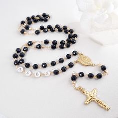 Introducing our exquisite Personslized Rosary beads for men or women, meticulously handcrafted with a touch of elegance and spirituality. This captivating piece features a striking black onyx stone, and handcrafted letter on mother of pearl beads. The gold plated & fine wire-wrapping adds a contemporary twist, creating a unique and stylish design that effortlessly blends tradition with modern fashion. This Rosary Necklace is not just a statement accessory, but also a symbol of faith and devotion Black Beads Cross Rosary Gift, Personalized Black Spiritual Jewelry, Personalized Black Spiritual Necklaces, Personalized Spiritual Black Necklaces, Black Spiritual Jewelry With Letter Beads, Personalized Spiritual Rosary Gift, Spiritual Letter Beads Necklace For Gift, First Communion Boy, Black Rosary