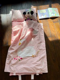 a child's sleeping bag on the floor with a stuffed animal laying in it