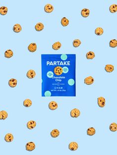 a package of cookie cookies sitting on top of a blue surface with lots of smaller cookies scattered around it