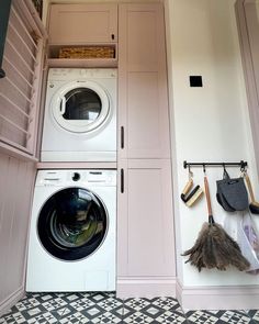 there is a washer and dryer in this small laundry room with pink cabinets