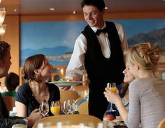 a waiter serving food to people at a restaurant