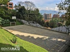 an empty basketball court in the middle of a park