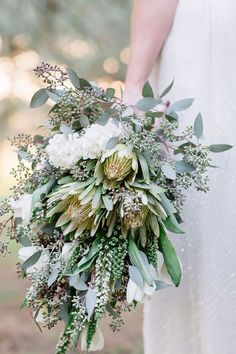 a bridal holding a bouquet of flowers and greenery