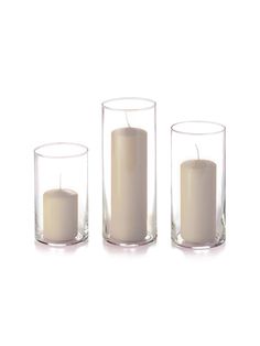 three clear glass candles are sitting in front of each other