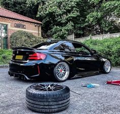 a black car parked next to a pile of tires