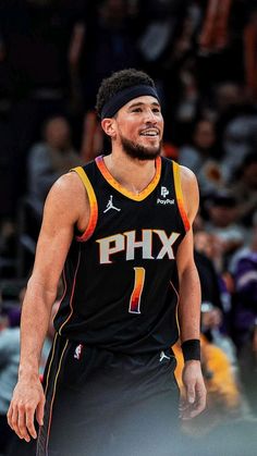 a basketball player is smiling while standing in front of an audience with his headband on