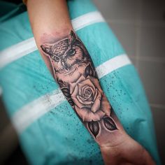 a person with a tattoo on their arm and an owl holding a rose in his hand