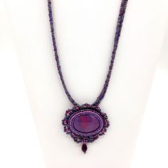 "An original handmade piece by: CharmedByRebecca. This beaded cabochon necklace was handmade with polymer clay, resin and added beadwork .  The oblong pendant is created with beautiful vibrant color mixtures of purple and fuchsia, formed into a large oblong shape that measures 1.75in wide by 1.5in height.  (with beads added measurement is 2\" x 2.5\" w).  Embroidered Beadwork  was added to accent & blend the colors of the pendant.  Seed bead colors are of Amethyst/Dark Rose, Lilac, Dark Amethyst Handmade Purple Beaded Pendant Necklace, Handmade Purple Pendant Beaded Necklace, Purple Beaded Pendant Necklaces, Purple Beaded Pendant Necklace, Handmade Purple Beads For Crafting, Purple Handmade Beads For Crafting, Purple Oval Beaded Necklaces For Jewelry Making, Handmade Purple Oval Necklace, Weaving Necklace