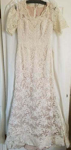 a white lace dress hanging on a hanger