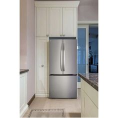 a stainless steel refrigerator in a kitchen with white cabinets and granite counter tops, along with an area rug on the floor