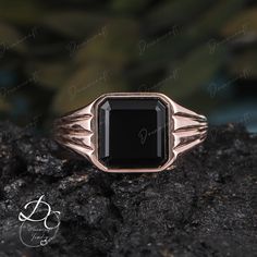 a black stone ring sitting on top of a rock