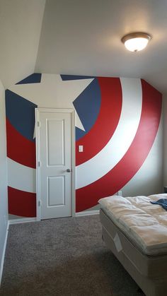 a bedroom with a captain america mural painted on the wall and a bed in front of it