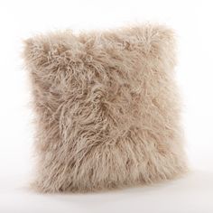 a furry pillow sitting on top of a white floor