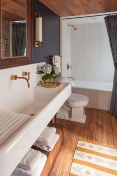 a bathroom with wood paneling and white fixtures